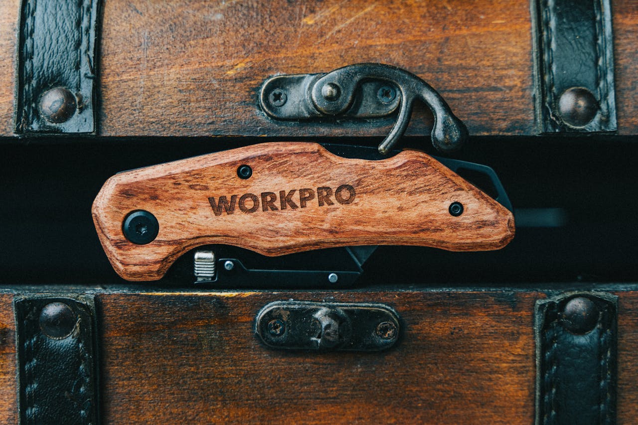 Close-up of a wooden multi-tool knife set against an antique chest, showcasing craftsmanship.