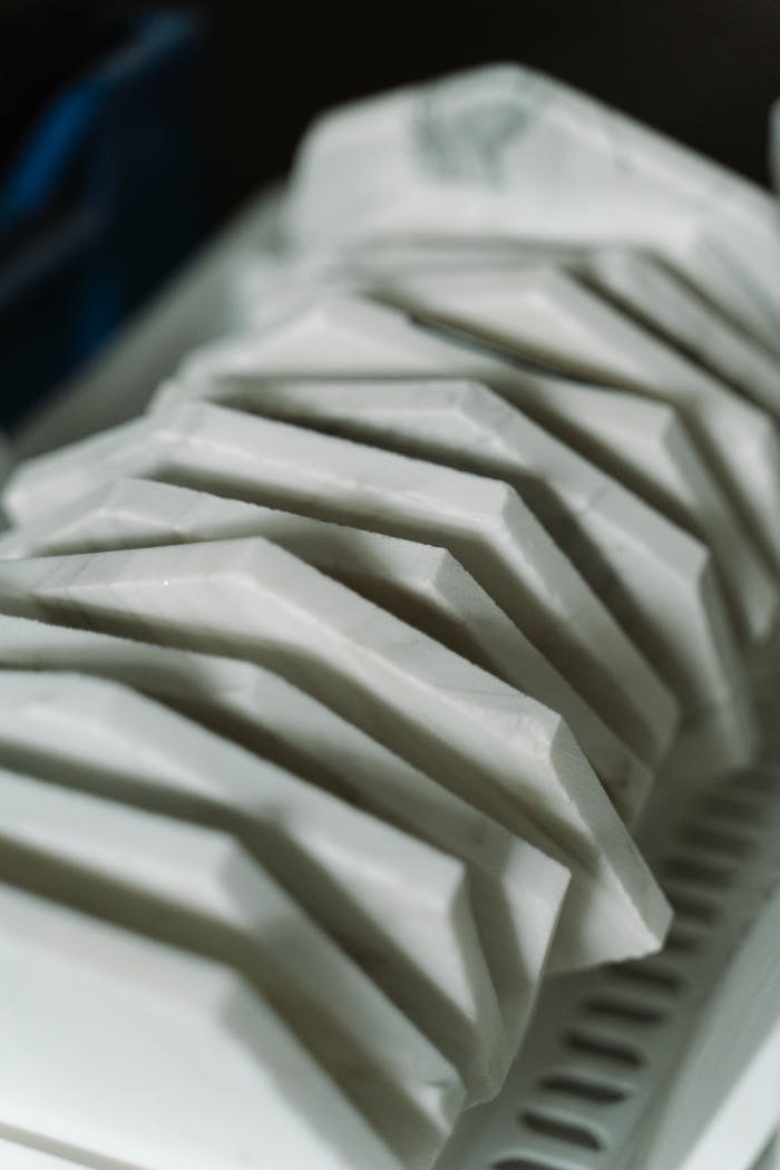 Close-up of white ceramic plates neatly stacked on a drying rack, emphasizing kitchen organization.